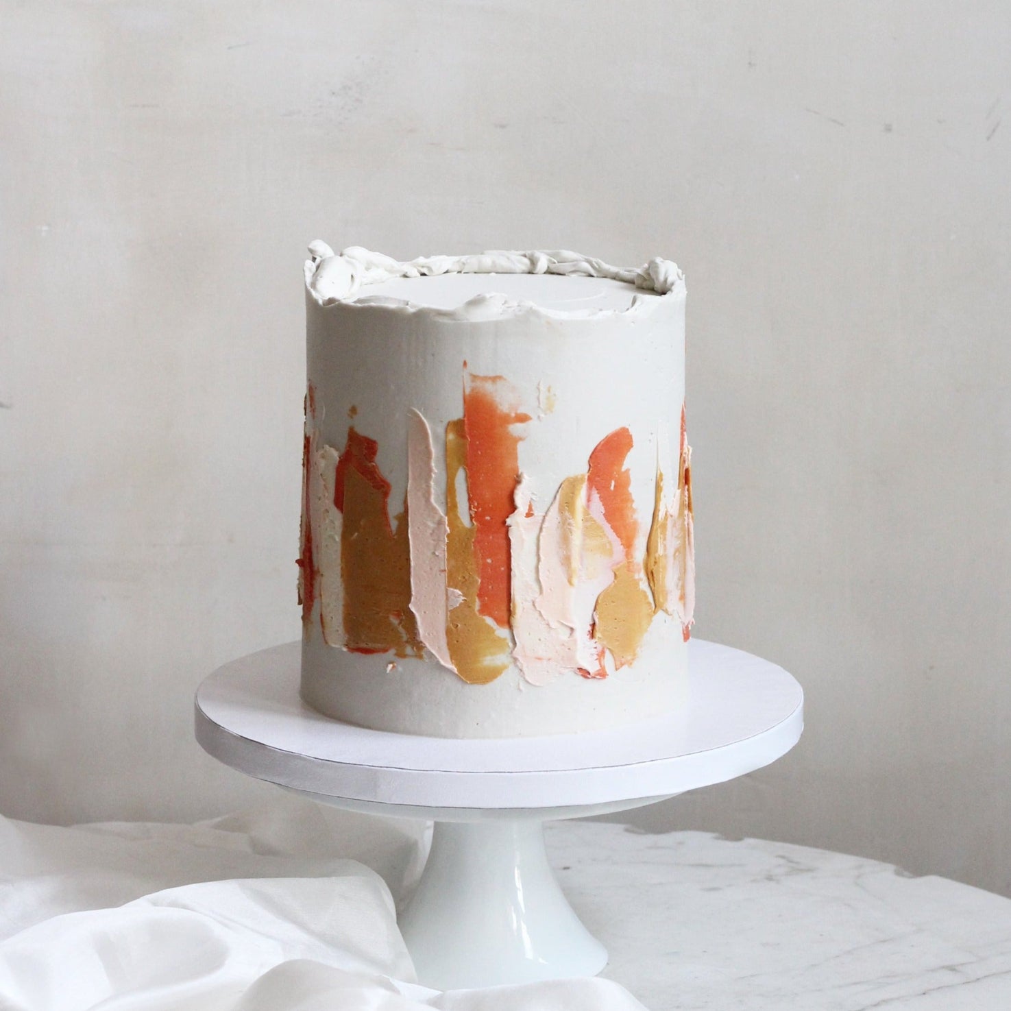Our signature LUIZA cake decorated with abstract strokes in warm earthy tones.