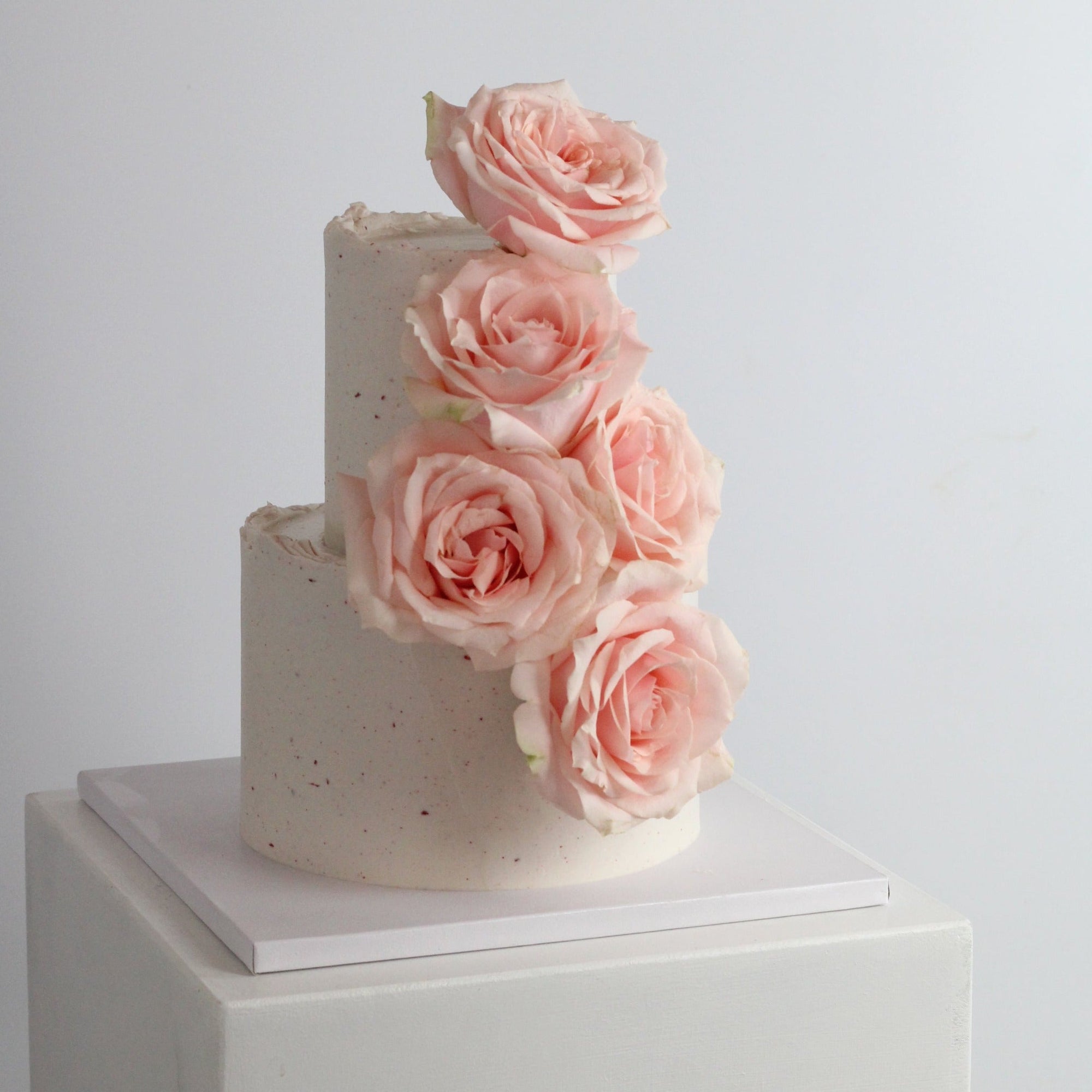 Our seasonal Rosie Cake iced with raspberry cream and topped with fresh roses, in 2-tier version.