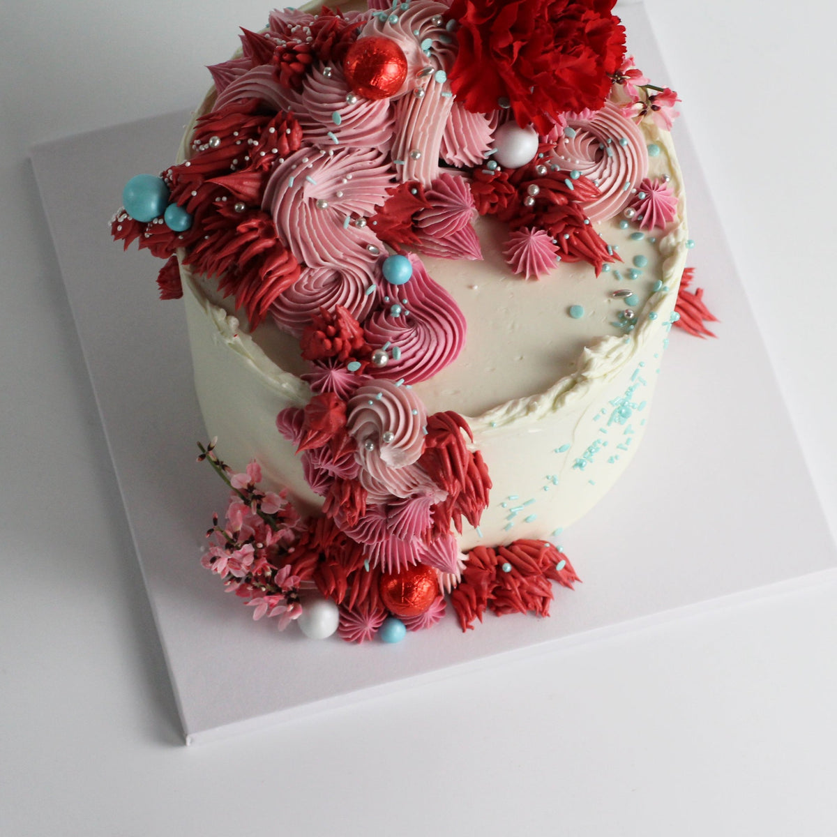 Our signature Shag Cake in red tones, covered in shaggy buttercream!