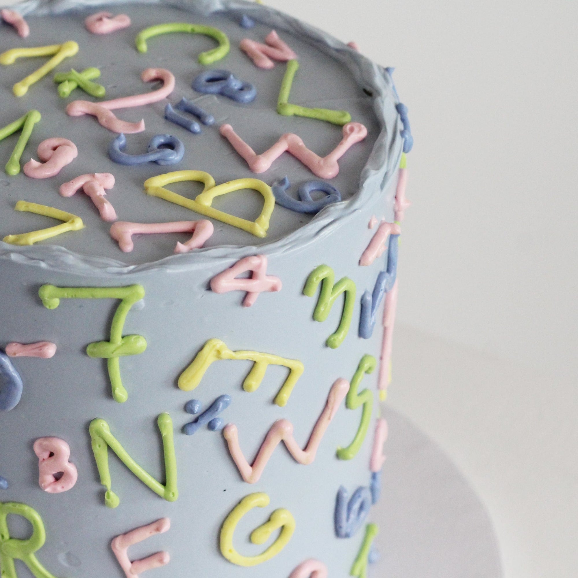 Celebrate the first day of school with this retro 90s-style ABC 123 cake, inspired by the classic Einschulung torte. Featuring hand-drawn letters and numbers in vibrant pop colors against a pastel background, it's the ultimate treat for unforgettable Einschulung enrollment parties and milestone celebrations.