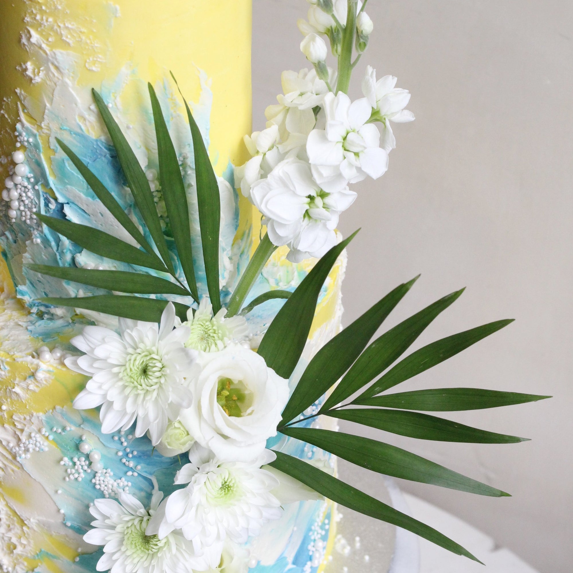 Beach-inspired cake with wavy brushstrokes and a dash of white florals.