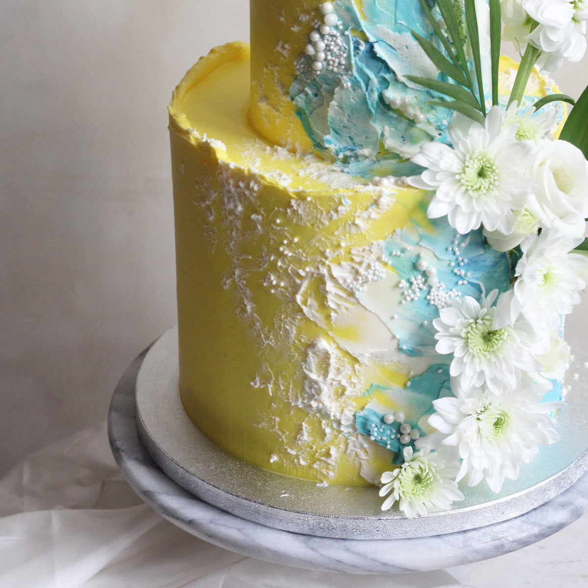 Beach-inspired cake with wavy brushstrokes and a dash of white florals.