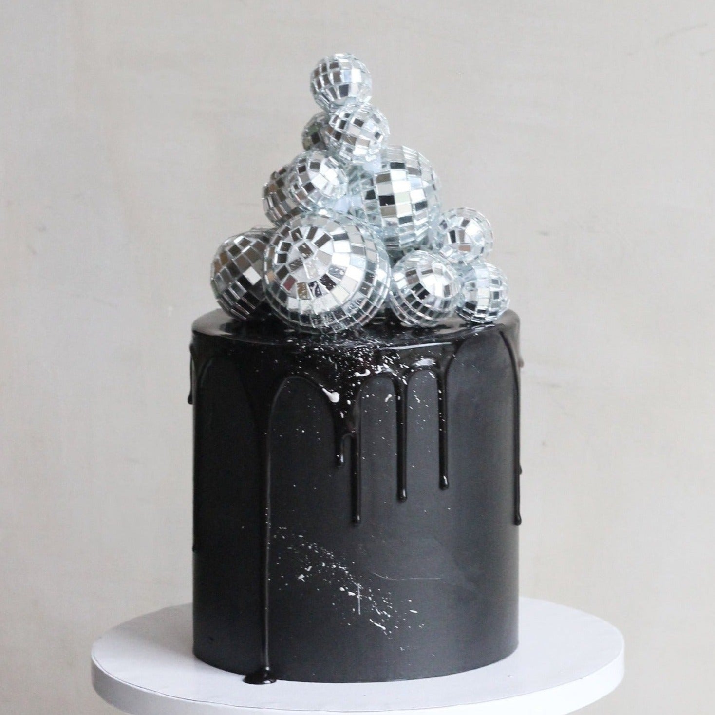 Black party cake topped with shiny disco balls, perfect for birthdays, celebrations, dance parties, and glamorous dessert tables. Stylish and eye-catching cake for festive occasions.