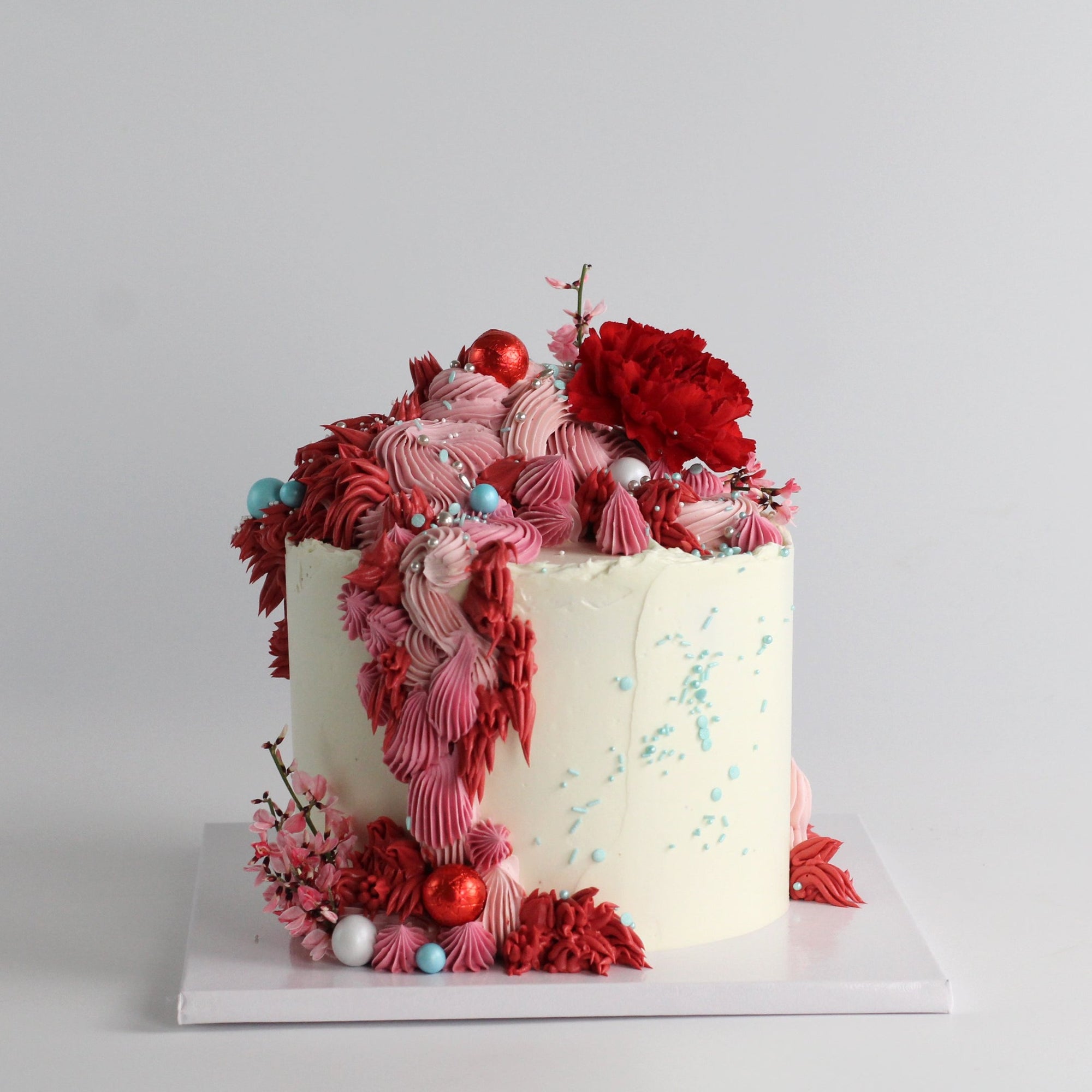 Our signature Shag Cake in red tones, covered in shaggy buttercream!