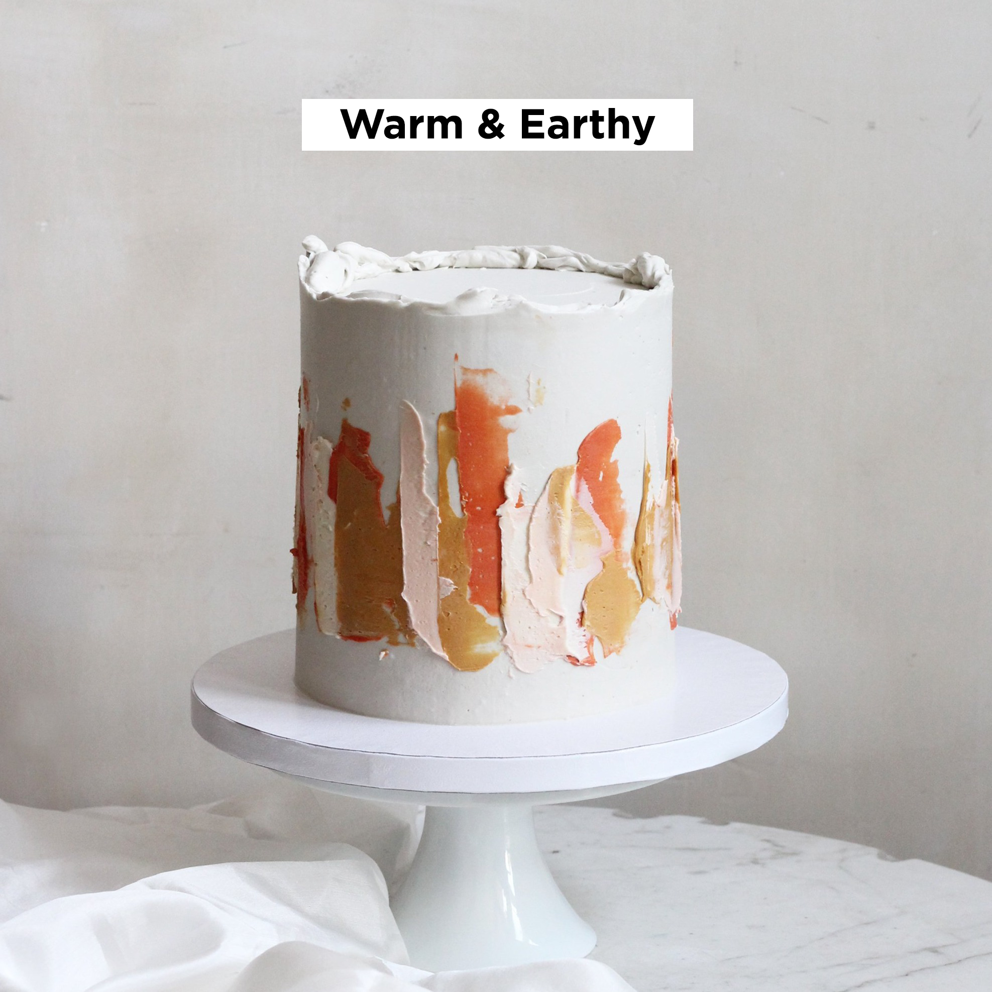 Our signature LUIZA cake adorned with abstract strokes in warm amber, peach, and gold tones.